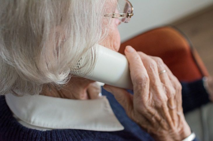 Пожилая женщина говорит по телефону