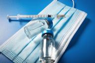 Защитная маска, шприц и вакцина 