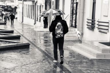 парень идет под зонтом