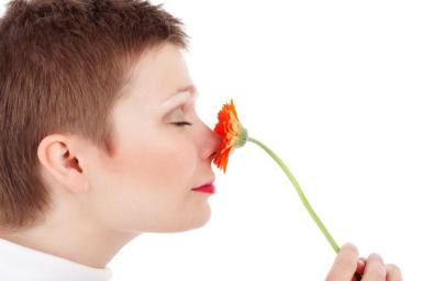 женщина нюхает цветок